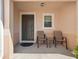 Cozy front porch with seating, a small table, and a dark-colored front door with sidelight window at 3071 Seaview Castle Dr, Kissimmee, FL 34746
