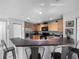 Eat-in kitchen with bar seating features light wood cabinets, stainless steel appliances, and tile flooring at 3071 Seaview Castle Dr, Kissimmee, FL 34746