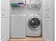 This is a simple laundry room featuring a front-load washer and dryer with wire shelves at 3071 Seaview Castle Dr, Kissimmee, FL 34746