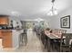 Open-concept living and dining area with wood-look floors, stylish bar seating, and sliding glass doors to the outdoors at 3071 Seaview Castle Dr, Kissimmee, FL 34746