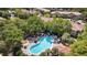 Aerial shot of community pool surrounded by lush trees and well-maintained buildings at 3071 Seaview Castle Dr, Kissimmee, FL 34746