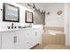 Bright bathroom features double vanity, quartz counters, stylish fixtures, and a soaking tub at 308 Yellow Snapdragon Dr, Davenport, FL 33837