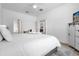 Inviting bedroom with white bedding, a ceiling fan, and a glimpse into the adjacent bathroom at 308 Yellow Snapdragon Dr, Davenport, FL 33837