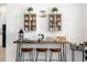 Chic coffee bar with stylish stools, modern appliances, and decorative storage shelves at 308 Yellow Snapdragon Dr, Davenport, FL 33837
