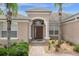 Elegant entryway featuring a dark wood door, decorative columns, and lush landscaping at 308 Yellow Snapdragon Dr, Davenport, FL 33837