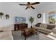 Bright living room boasts a ceiling fan, neutral decor, comfortable seating, and a flatscreen TV at 308 Yellow Snapdragon Dr, Davenport, FL 33837
