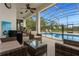 Spacious covered patio with mini-fridge and comfortable lounge seating next to a screened pool enclosure at 308 Yellow Snapdragon Dr, Davenport, FL 33837