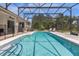 Inviting pool area with a view of the fenced backyard and a screened enclosure at 308 Yellow Snapdragon Dr, Davenport, FL 33837