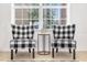 Cozy sitting area with comfortable plaid chairs and a coffee table, illuminated by natural light at 308 Yellow Snapdragon Dr, Davenport, FL 33837