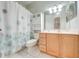 Fresh bathroom with light wood cabinets, white tile, and a patterned shower curtain at 3181 Bayview Ln, St Cloud, FL 34772