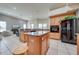 Open-concept kitchen with central island, wood cabinets, tile floors, and modern appliances overlooking the living area at 3181 Bayview Ln, St Cloud, FL 34772