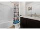 Well-lit bathroom with a single sink vanity and toilet with a blue seat next to the tub/shower combo at 341 Gardenia Ct, Kissimmee, FL 34759