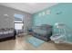 Light-filled Bedroom with gray crib, mobile, playpen, and a calming blue accent wall at 341 Gardenia Ct, Kissimmee, FL 34759