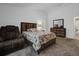 Comfortable bedroom with wood headboard, matching dresser, and plush chair on neutral carpeting at 341 Gardenia Ct, Kissimmee, FL 34759