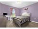 Cozy bedroom with lilac walls, a plush bed, a computer desk and window with natural light at 341 Gardenia Ct, Kissimmee, FL 34759