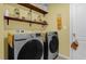 Well-organized laundry room featuring floating shelves and modern washer and dryer units at 341 Gardenia Ct, Kissimmee, FL 34759