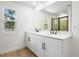 Bathroom features double sinks with sleek black fixtures, tile flooring, and large mirror at 3765 Deer Ridge Dr, Mount Dora, FL 32757