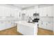 Bright, white kitchen features modern appliances, a large center island, and stylish backsplash at 3765 Deer Ridge Dr, Mount Dora, FL 32757