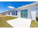 Backyard patio with sliding glass door and windows, overlooking green grass and pond at 4928 Worchester Dr, Kissimmee, FL 34746