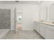 Spacious bathroom with double vanity, walk-in shower, and gray tile flooring at 4928 Worchester Dr, Kissimmee, FL 34746