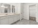Bright bathroom features a double vanity with white cabinets and gray tile flooring at 4928 Worchester Dr, Kissimmee, FL 34746