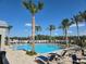 Community pool with palm trees and plenty of lounge seating for residents on a sunny day at 4928 Worchester Dr, Kissimmee, FL 34746