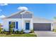 Charming one-story home with blue door, blue shutters, and a two car garage on a sunny day at 4928 Worchester Dr, Kissimmee, FL 34746