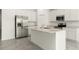 Stylish kitchen boasts an island with a sink, stainless steel appliances, and white cabinetry at 4928 Worchester Dr, Kissimmee, FL 34746