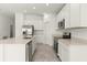 Modern kitchen with stainless steel appliances, an island sink, and sleek white cabinets at 4928 Worchester Dr, Kissimmee, FL 34746