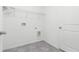 Functional laundry room with wire shelving, tile flooring, and hookups for a washer and dryer at 4928 Worchester Dr, Kissimmee, FL 34746
