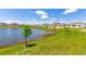 Backyard view featuring pond with lush green grass and neighborhood homes at 4928 Worchester Dr, Kissimmee, FL 34746