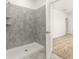 Modern walk-in shower featuring gray tile and an open doorway to carpeted bedroom at 4928 Worchester Dr, Kissimmee, FL 34746