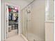 Bathroom with walk-in shower, neutral tile, glass door, and convenient access to the walk-in closet at 6821 Cultivation Way, Winter Garden, FL 34787