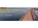 Wooden community dock on a serene lake with reflections of the sky at 6821 Cultivation Way, Winter Garden, FL 34787