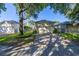 Paver driveway leading to a three-car garage with mature landscaping at 6821 Cultivation Way, Winter Garden, FL 34787