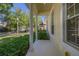 Covered porch area with supporting columns and manicured bushes, creating a serene and inviting entrance at 6821 Cultivation Way, Winter Garden, FL 34787