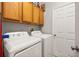 Convenient laundry room with overhead cabinets, and a white washer and dryer at 6821 Cultivation Way, Winter Garden, FL 34787