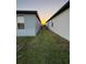 Side yard view featuring a grassy area between two houses at sunset at 748 Citrus Isle Dr, Davenport, FL 33837