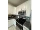 Kitchen with white cabinets, stainless steel appliances, and stylish backsplash at 748 Citrus Isle Dr, Davenport, FL 33837