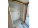 Small laundry room space with white tile flooring and floating shelves at 781 W Lancaster Rd # B38, Orlando, FL 32809