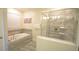 Modern bathroom featuring a tub and glass shower with neutral toned tile at 9042 Stinger Dr, Davenport, FL 33896