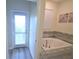 Bathroom with jacuzzi style tub and door leading to outside at 9042 Stinger Dr, Davenport, FL 33896