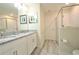 Well-lit bathroom with double sinks, granite counters, and glass shower at 9042 Stinger Dr, Davenport, FL 33896