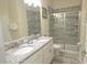Modern bathroom with double sinks, granite counters, and a glass shower at 9042 Stinger Dr, Davenport, FL 33896