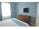 Comfortable bedroom featuring a bed, dresser, and neutral decor, complete with a TV at 9042 Stinger Dr, Davenport, FL 33896