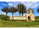 Beautiful entrance to Champions Gate with manicured landscaping and bright yellow signage at 9042 Stinger Dr, Davenport, FL 33896