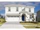 Stunning two-story home features a pristine white exterior and a welcoming blue front door at 9042 Stinger Dr, Davenport, FL 33896