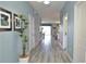Inviting hallway featuring stylish gray flooring, blue walls, and plant decor at 9042 Stinger Dr, Davenport, FL 33896