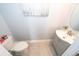 Stylish powder room featuring a modern vanity, round mirror, and toilet, showcasing contemporary design at 9056 Wildflower Ln, Kissimmee, FL 34747