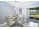 Cozy dining area with a glass table, modern chandelier, and sliding doors to the outdoor space at 9056 Wildflower Ln, Kissimmee, FL 34747